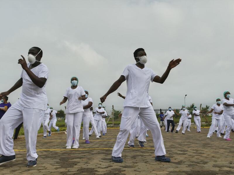 Nurses assigned to the Infectious Diseases Unit (IDU) at the Kenyatta University Hospital dance during a Zumba class held at the hospital compound in Nairobi, on May 17, 2020. Coinciding with the morning shift rotation the class, aimed to offer some respite to nurses charged with the management of patients infected with COVID-19 coronavirus, was organised by the Nursing Council of Kenya (NCK) and the Kenyatta Univesity Teaching, Refferal and Research Hospital in the Kenyan capital. TONY KARUMBA / AFP