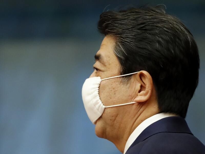 Japan's Prime Minister Shinzo Abe wears a face mask as he enters a venue for his news conference in Tokyo on May 25, 2020. Japan lifted a nationwide state of emergency over the coronavirus on May 25, gradually reopening the world's third-largest economy as government officials warned caution was still necessary to prevent another wave. KIM KYUNG-HOON / POOL / AFP