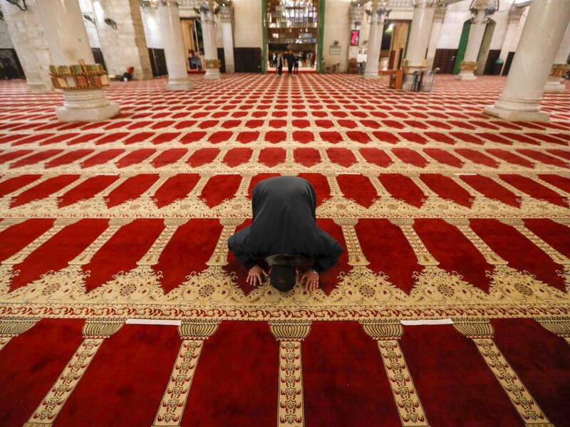 A Palestinian man performs the morning prayer inside Al-Aqsa mosque, before the start of the dawn prayer (salat al-fajr) in Jerusalem's Old City, on May 31, 2020, after a two-month closure due to the COVID-19 pandemic. AHMAD GHARABLI / AFP