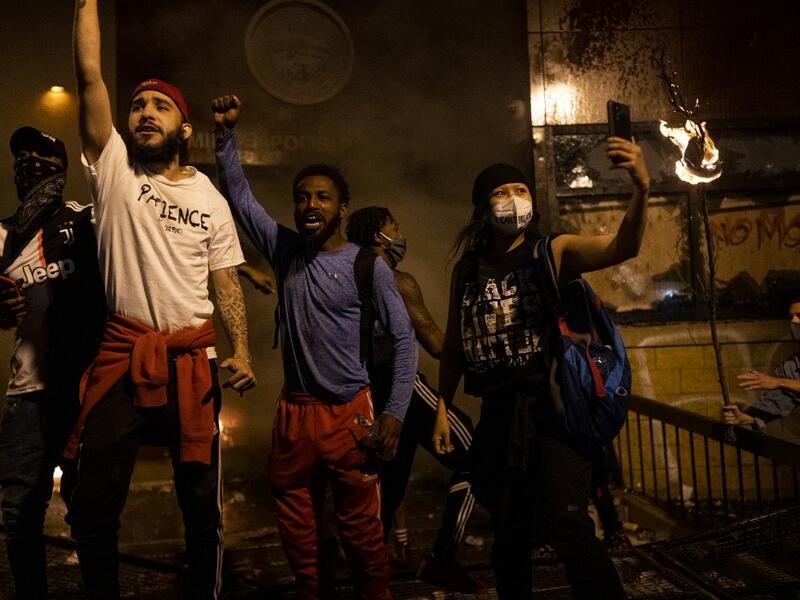 Protesters cheer as the Third Police Precinct burns behind them on May 28, 2020 in Minneapolis, Minnesota. As unrest continues after the death of George Floyd, police abandoned the precinct building, allowing protesters to set fire to it. Stephen Maturen/Getty Images/AFP