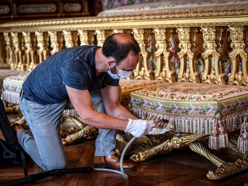 A worker cleans the Queen bedroom (Chambre de la Reine) at the Chateau de Versailles (Palace of Versailles) in Versailles near Paris, on June 5, 2020 on the eve of it re-opening after 82 days of closure due to the novel coronavirus (COVID-19) outbreak. The Palace of Versailles -- France's big tourist attraction with nearly 10 million tourists a year - will open on June 6 with no US or Asia tourists who represent 30% of its visitors. STEPHANE DE SAKUTIN / AFP