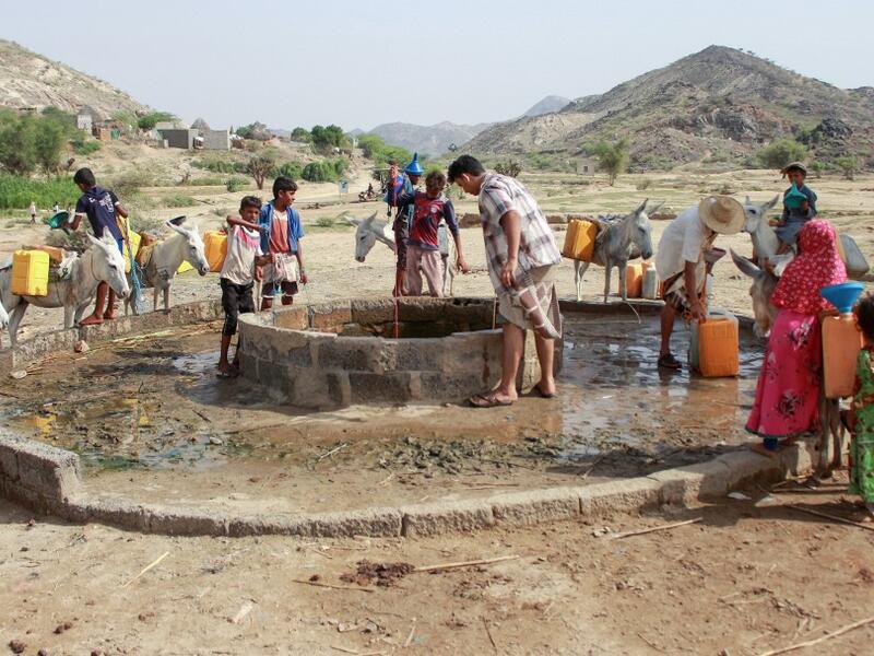 Yemenis fill their jerrycans carried by donkeys, with water from a cistern at a make-shift camp for the internally displaced, in the northern Hajjah province, on June 7, 2020, amid a severe shortage of water. ESSA AHMED / AFP