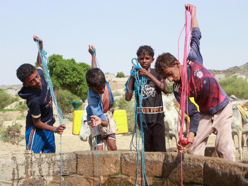 Yemeni youths fill jerrycans carried by donkeys with water from a cistern at a make-shift camp for the internally displaced, in the northern Hajjah province, on June 7, 2020, amid a severe shortage of water. ESSA AHMED / AFP
