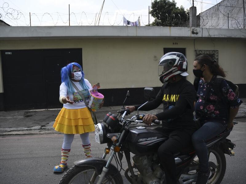 A clown begs for money to survive the crisis caused by the new coronavirus in Villa Nueva, 20 km south Guatemala City, on June 10, 2020, as clowns have been unable to work due to restrictions to prevent the spread of the COVID-19.    Johan ORDONEZ / AFP