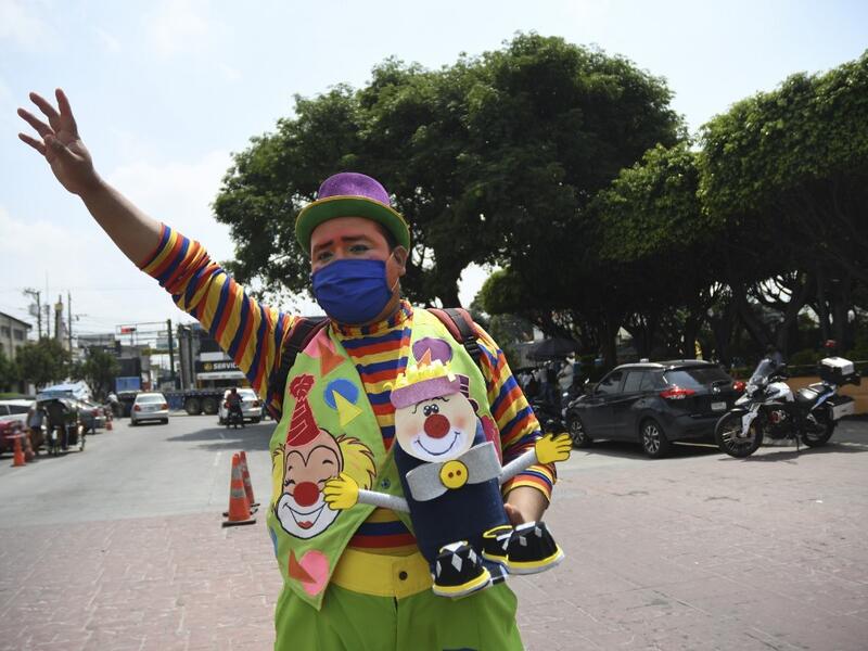 A clown begs for money to survive the crisis caused by the new coronavirus in Villa Nueva, 20 km south Guatemala City, on June 10, 2020, as clowns have been unable to work due to restrictions to prevent the spread of the COVID-19. Johan ORDONEZ / AFP