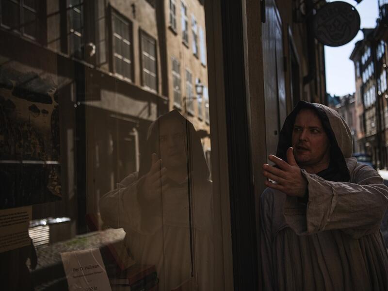 Tour guide Mike Anderson takes visitors on May 30 ,2020 on a 'plague walk', taking them around sites in Stockholm's old town related to pandemics of the plague in the 14th and 18th century, and an outbreak of cholera that hit the city in the mid-19th century. Jonathan NACKSTRAND / AFP