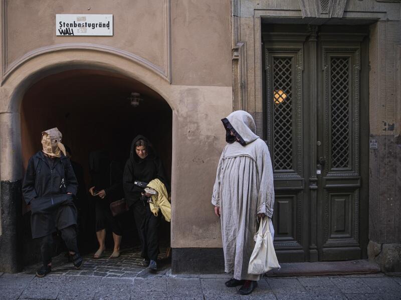 Tour guide Mike Anderson takes visitors on May 30 ,2020 on a 'plague walk', taking them around sites in Stockholm's old town related to pandemics of the plague in the 14th and 18th century, and an outbreak of cholera that hit the city in the mid-19th century. Jonathan NACKSTRAND / AFP
