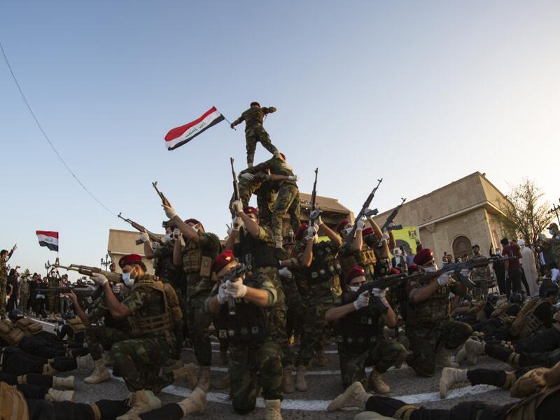 Members of the Hashed al-Shaabi (Popular Mobilisation) paramilitary force take part in a military parade in the southern Iraqi city of Basra on June 14, 2020, marking the sixth anniversary of its founding after Iraq's top Shiite cleric Grand Ayatollah Ali Sistani called to defend the country from the Islamic State group (IS). Hussein FALEH / AFP