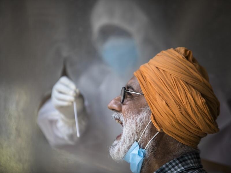 A health official collects a swab sample from a man to test for the COVID-19 coronavirus at a temporary testing center at a hotel after authorities eased restrictions imposed as a preventive measure against the spread of the COVID-19 coronavirus, in New Delhi on June 17, 2020. India's official coronavirus death toll leapt by more than 2,000 on June 17 as the hard-hit country struggles to contain a ballooning health crisis that has overwhelmed hospitals. The news came as Germany urged its nationals in India 