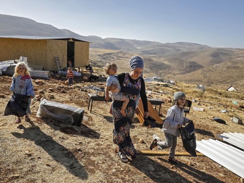 An Israeli settler woman walks with children in the Maoz Ester outpost located next to the Israeli settlement of Kokhav HaShahar in the occupied West Bank on June 18, 2020. The government of Israeli Prime Minister Benjamin Netanyahu has said it could begin the process to annex Jewish settlements in the West Bank as well as the strategic Jordan Valley from July 1. The plan -- endorsed by Washington -- would see the creation of a Palestinian state, but on reduced territory, and without Palestinians' core dema