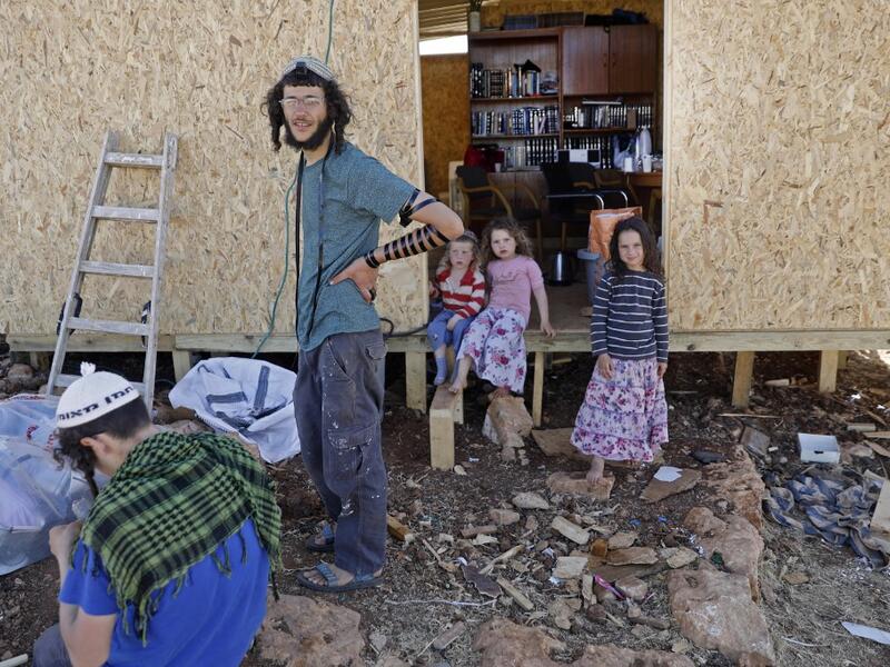 An Israeli settler wearing the Tefillin or phylacteries is picture at his home in the Maoz Ester outpost located next to the Israeli settlement of Kokhav HaShahar in the occupied West Bank on June 18, 2020. The government of Israeli Prime Minister Benjamin Netanyahu has said it could begin the process to annex Jewish settlements in the West Bank as well as the strategic Jordan Valley from July 1. The plan -- endorsed by Washington -- would see the creation of a Palestinian state, but on reduced territory, a