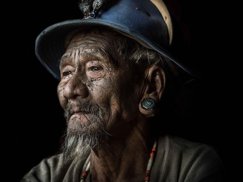 An elderly Konyak tribesman wears thick ear plugs and sports a goatee while dressed in more western clothes than the tribe would have traditionally worn. (Mediadrumimages/ Trevor Cole)