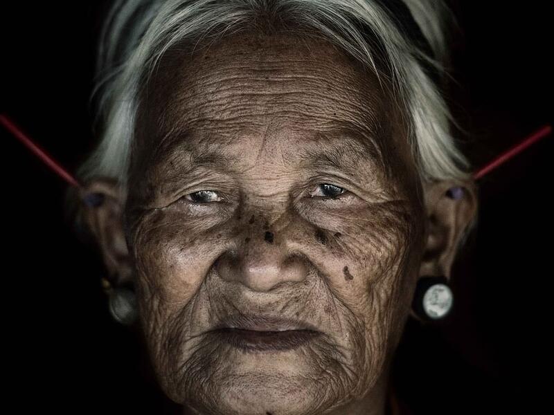 A woman from the Konyak tribe wears plugs in her both her lobes while another set, believed to be made from bone, protrude at jagged angles from the top of her ears. (Mediadrumimages/ Trevor Cole)