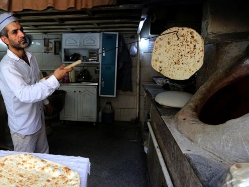 Iranian baker Mohammad Mirzakhani, 41, makes Taftoon bread in Tehran on June 13, 2020. ATTA KENARE / AFP