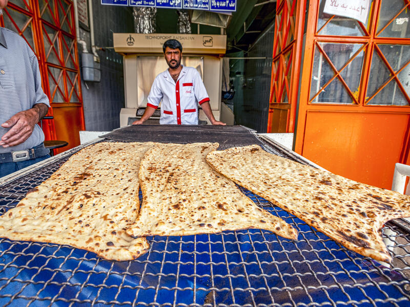 Fars Province Iran, bakers are baking Sangak bread in a traditional oven by traditional method, Sangak bread was traditionally the bread of the Persian army  (Shutterstock)	