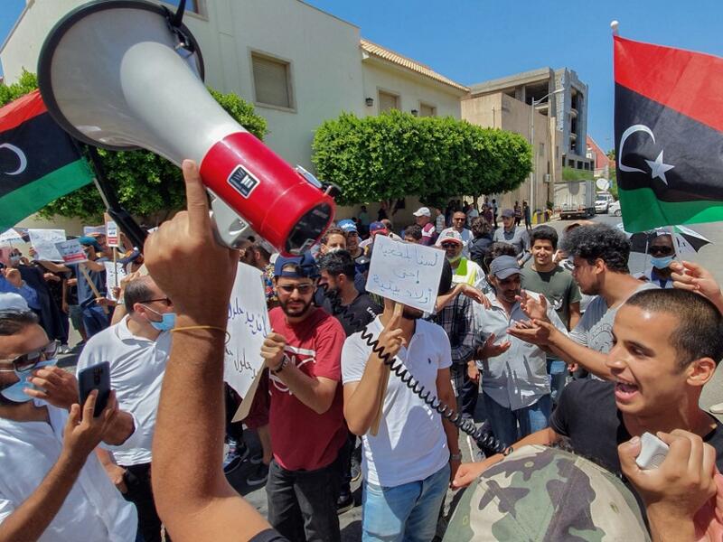 Libyans lift placards at a rally in front of the Prime Ministers headquarters in the capital Tripoli to protest frequent electricity cuts, on July 1, 2020. Mahmud TURKIA / AFP