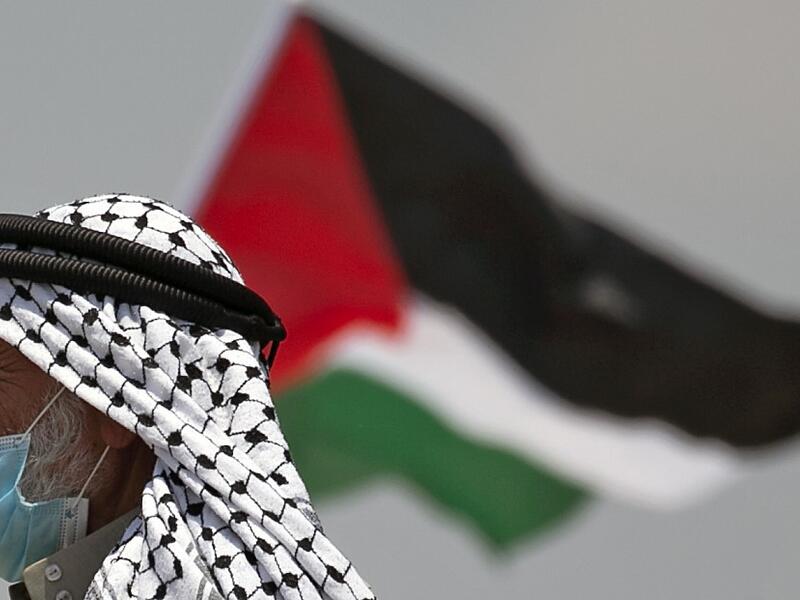 A Palestinian demonstrator waves a national flag during a protest against the expansion of existing Jewish settlements, in the town of Biddya, in the Israeli-occupied West Bank on July 6, 2020. JAAFAR ASHTIYEH / AFP