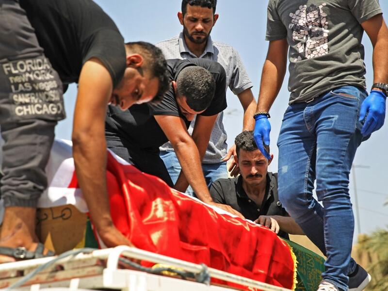 Mourners transport the coffin of slain Iraqi jihadism expert Hisham al-Hashemi, who was shot dead yesterday outside his house in the Iraqi capital, during his funeral in Baghdad’s Zayouna district on July 7, 2020. Hashemi was an authoritative voice on Sunni jihadist factions including the Islamic State group, but was also frequently consulted by media and foreign governments on domestic Iraqi politics and Shiite armed groups. 