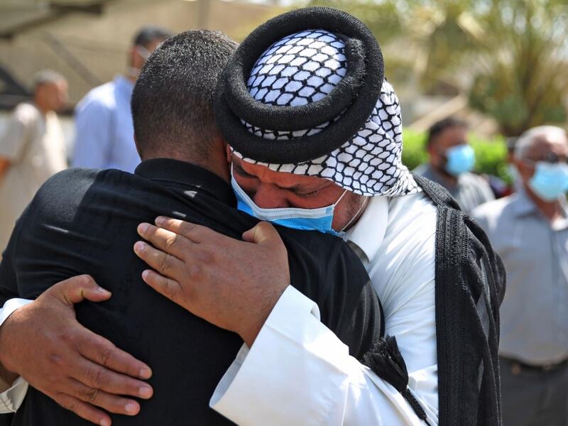 Mourners embrace during the funeral of slain Iraqi jihadism expert Hisham al-Hashemi, who was shot dead yesterday outside his house in the Iraqi capital, in Baghdad’s Zayouna district on July 7, 2020. Hashemi was an authoritative voice on Sunni jihadist factions including the Islamic State group, but was also frequently consulted by media and foreign governments on domestic Iraqi politics and Shiite armed groups. He had warm ties with top decision-makers, including President Barham Saleh.