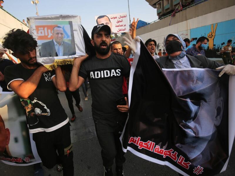 Iraqi demonstrators stage a symbolic funeral for slain Iraqi jihadism expert Hisham al-Hashemi, who was shot dead yesterday outside his house in the Iraqi capital, on July 7, 2020 at Baghdad's Tahrir square. The killing of the 47-year-old prominent expert has stirred fears Iraq is entering a dark and violent phase, as boiling tensions between pro-Iran factions and the government reach new heights. AHMAD AL-RUBAYE / AFP