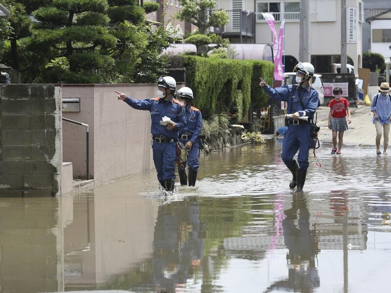Fire brigade officers check on residents following heavy rain in Omuta, Fukuoka Prefecture on July 8, 2020. Torrential rain pounded central Japan on July 8 as authorities said 58 people were feared dead in days of heavy downpours that have triggered devastating landslides and terrifying floods. STR / JIJI PRESS / AFP