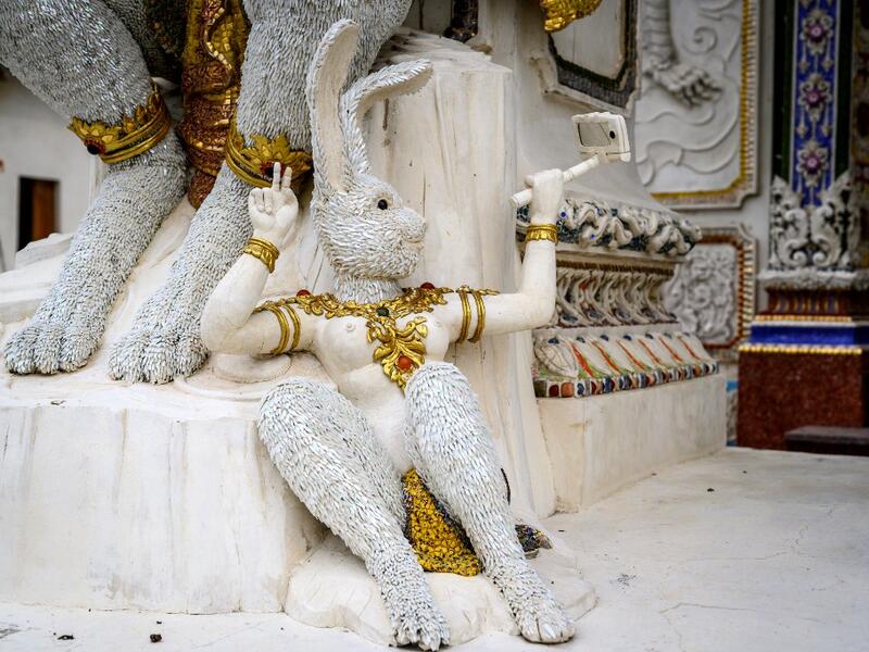 This photograph taken on July 14, 2020 shows a statue of an imaginary rabbit-like creature taking a selfie outside the Wat Pariwat Buddhist temple in Bangkok. Wat Pariwat, also known as "the David Beckham Temple", is decorated with statues of superheroes and comic characters as well as mythical and imaginary creatures. A golden-plated sculpture of the English football player holding the base of a Buddha statue in one of the buildings gives the temple its nickname. Mladen ANTONOV / AFP