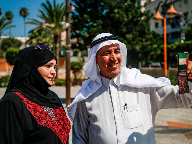 A Palestinian man takes a "selfie" on Palestinian traditional customs day, in Gaza City. AFP
