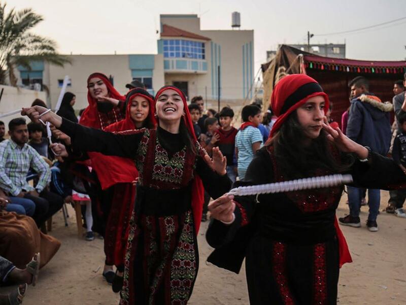 Palestinian girls dressed in traditional clothing dance during an event celebrating their culture in Khan Yunis, in the southern Gaza Strip. (AFP)