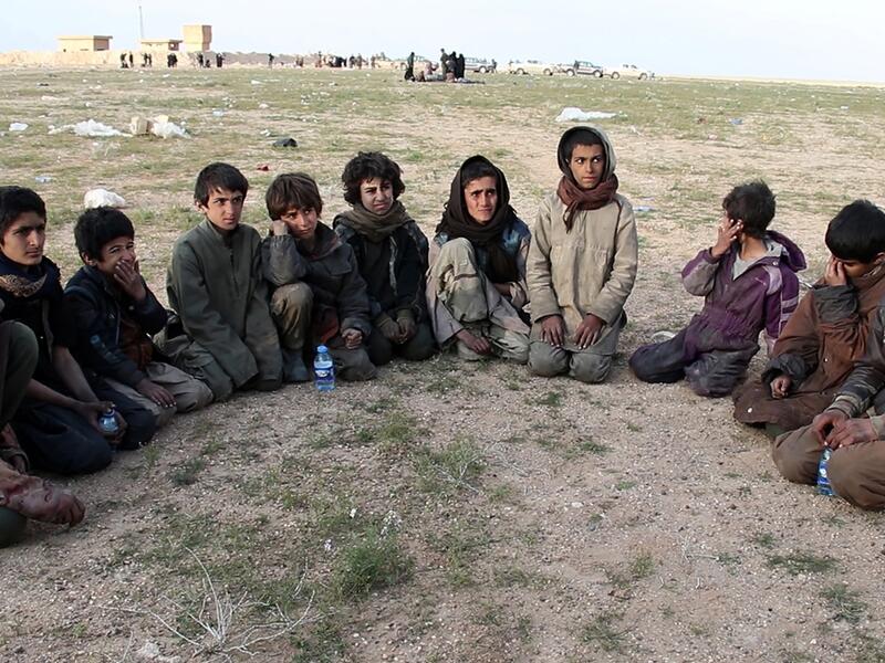Saddam, (R) a 15 year old Yazidi boy and ten other Yazidi children gather in a area held by the US-backed Kurdish-led Syrian Democratic Forces (SDF), in the eastern Syrian province of Deir Ezzor, after fleeing the Islamic State (IS) group's embattled holdout of Baghouz, on February 23, 2019. The eleven Yazidi children were rescued by US-backed forces from IS's last sliver of territory in the village of Baghouz near the Iraqi border. (AFP / -)