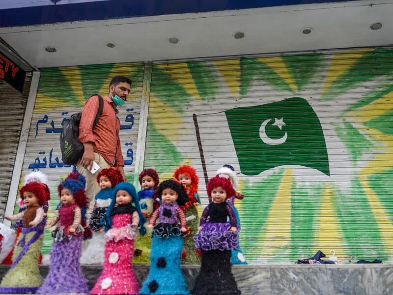 A man walks past a shuttered market in Rawalpindi on July 29, 2020, after the Punjab province government announced a lockdown closing markets, shopping malls and plazas to contain the spread of the COVID-19 coronavirus on the occasion of the Muslim festival Eid al-Adha or the 'Festival of Sacrifice'. Farooq NAEEM / AFP
