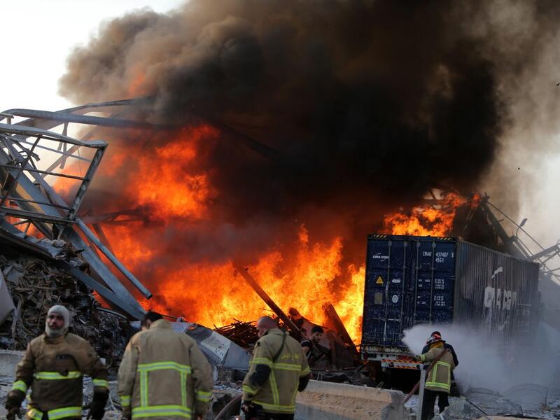 Lebanese firefights extinguish fire at the scene of an explosion at the port in the capital Beirut on August 4, 2020. Two huge explosion rocked the Lebanese capital Beirut, wounding dozens of people, shaking buildings and sending huge plumes of smoke billowing into the sky. Lebanese media carried images of people trapped under rubble, some bloodied, after the massive explosions, the cause of which was not immediately known.  STR / AFP