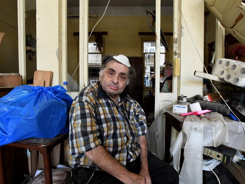 A man sits inside his damaged house in the Lebanese capital Beirut on August 6, 2020, two days after a massive explosion shook the Lebanese capital. The blast, which appeared to have been caused by a fire igniting 2,750 tonnes of ammonium nitrate left unsecured in a warehouse, was felt as far away as Cyprus, some 150 miles (240 kilometres) to the northwest. The scale of the destruction was such that the Lebanese capital resembled the scene of an earthquake, with thousands of people left homeless and thousan