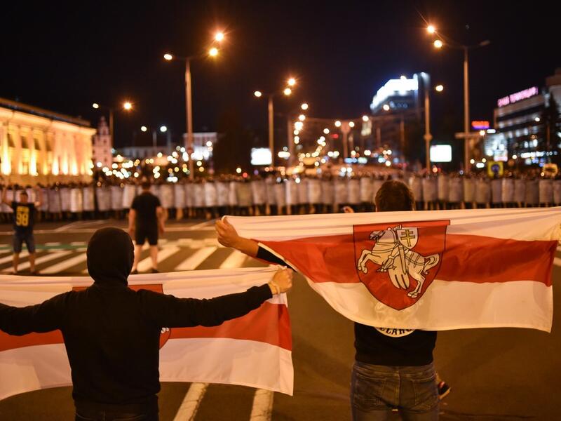 Demonstrators stand in front of riot police during a protest after polls closed in Belarus' presidential election, in Minsk on August 9, 2020. Sergei GAPON / AFP