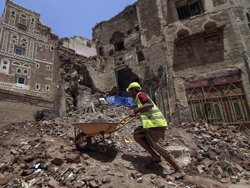 Yemeni labourers remove the rubble ahead of restoration works on the site of a collapsed UNESCO-listed building following heavy rains, in the old city of the Yemeni capital Sanaa, on August 12, 2020. Flash floods triggered by torrential rains have killed at least 172 people across Yemen over the past month, damaging homes and UNESCO-listed world heritage sites, officials said. Mohammed HUWAIS / AFP