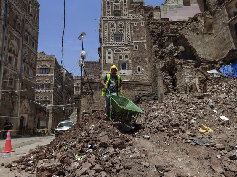 A Yemeni labourer removes the rubble ahead of restoration works on the site of a collapsed UNESCO-listed building following heavy rains, in the old city of the Yemeni capital Sanaa, on August 12, 2020. Flash floods triggered by torrential rains have killed at least 172 people across Yemen over the past month, damaging homes and UNESCO-listed world heritage sites, officials said. Mohammed HUWAIS / AFP