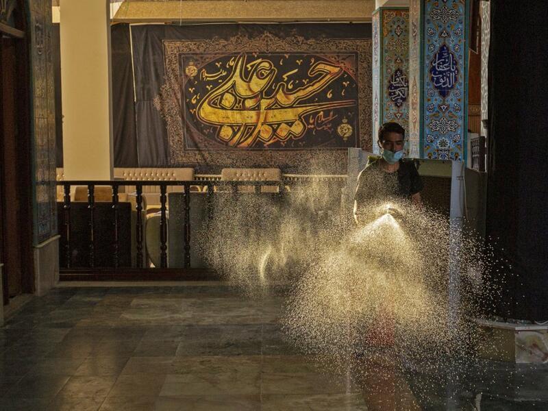 An Iraqi man disinfects a mosque on August 20, 2020, as Muslim Shiites start marking Ashura under new health guidelines to limit the risk of exposure to Covid-19 virus. Hussein FALEH / AFP