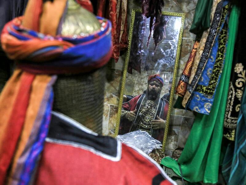 An Ashura re-enactor is assisted to get into costume before playing out a procession commemorating the entry of Imam Hussein and his family and retinue into Karbala, as Shiite Muslims mark the Ashura period in Iraq's central holy shrine city on August 22, 2020. Ashura is a period of mourning in remembrance of the seventh-century martyrdom of Prophet Mohammad's grandson Imam Hussein, who was killed in the battle of Karbala in modern-day Iraq, in 680 AD. Mohammed SAWAF / AFP