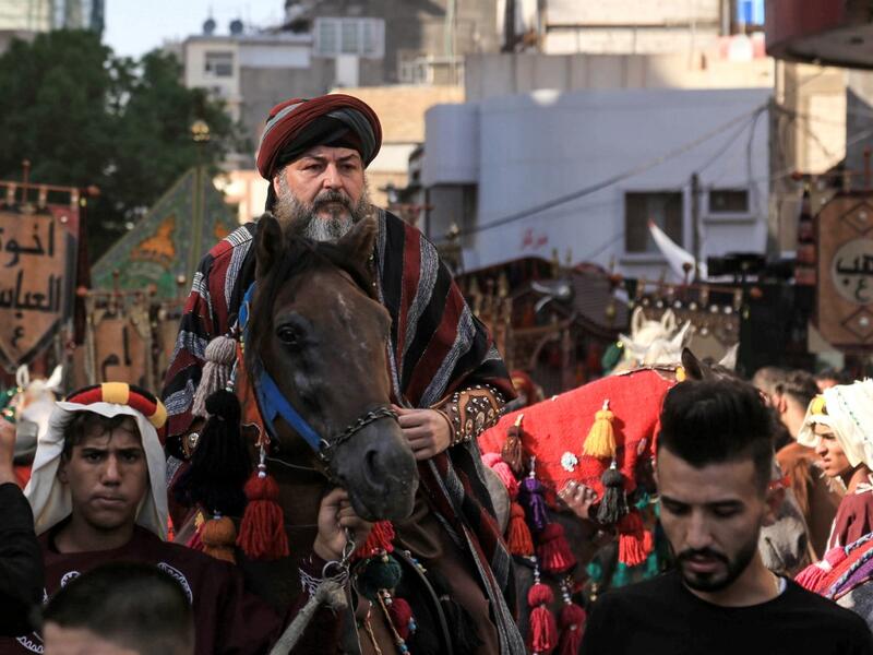 Ashura re-enactors in costume play out a procession commemorating the entry of Imam Hussein and his family and retinue into Karbala, as Shiite Muslims mark the Ashura period in Iraq's central holy shrine city on August 22, 2020. Ashura is a period of mourning in remembrance of the seventh-century martyrdom of Prophet Mohammad's grandson Imam Hussein, who was killed in the battle of Karbala in modern-day Iraq, in 680 AD. Mohammed SAWAF / AFP