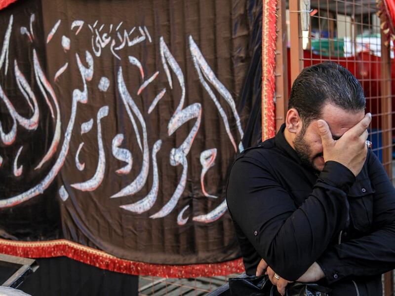 A man weeps on the side of a procession commemorating the entry of Imam Hussein and his family and retinue into Karbala, as Shiite Muslims mark the Ashura period in Iraq's central holy shrine city on August 22, 2020. Ashura is a period of mourning in remembrance of the seventh-century martyrdom of Prophet Mohammad's grandson Imam Hussein, who was killed in the battle of Karbala in modern-day Iraq, in 680 AD. Mohammed SAWAF / AFP