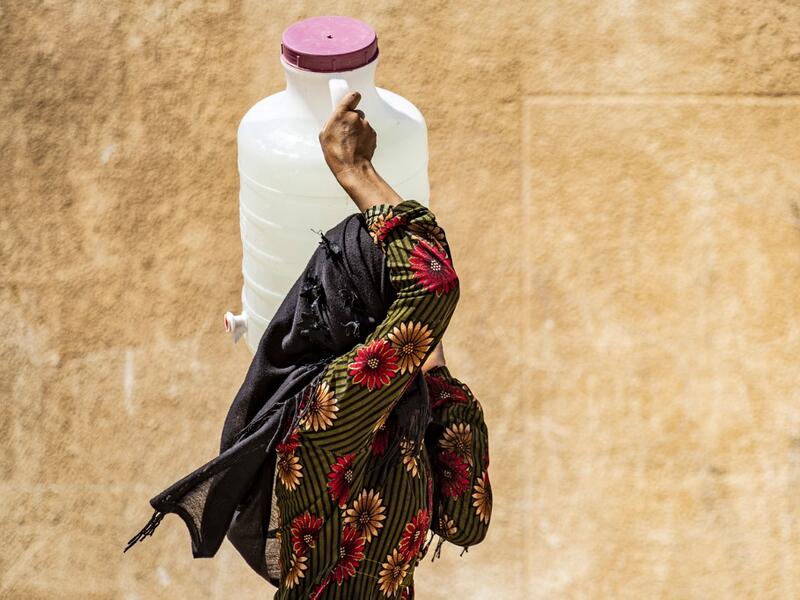 A displaced Syrian brings water back to their camp in a camp for the displaced in Syria's northeastern city of Hasakah on August 24, 2020. Delil SOULEIMAN / AFP