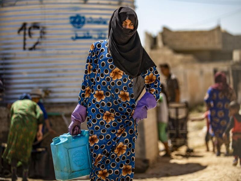 A displaced Syrian brings water back to their camp in a camp for the displaced in Syria's northeastern city of Hasakah on August 24, 2020. Delil SOULEIMAN / AFP