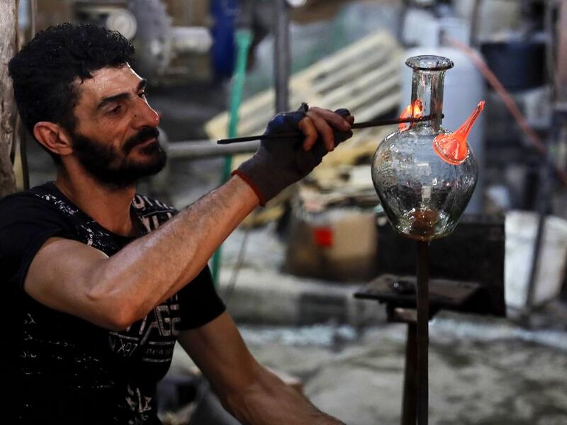 A glassblower forms glass at factory, which is recycling the broken glass as a result of the Beirut explosion, in the northern Lebanese port city of Tripoli on August 25, 2020. The August 4 port explosion ripped through countless glass doors and windows when it laid waste to whole Beirut neighbourhoods, killing at least 190 people and wounding thousands more. Volunteers, non-governmental groups and entrepreneurs salvaged a fraction of the tonnes of broken glass that littered the streets, some of it through 