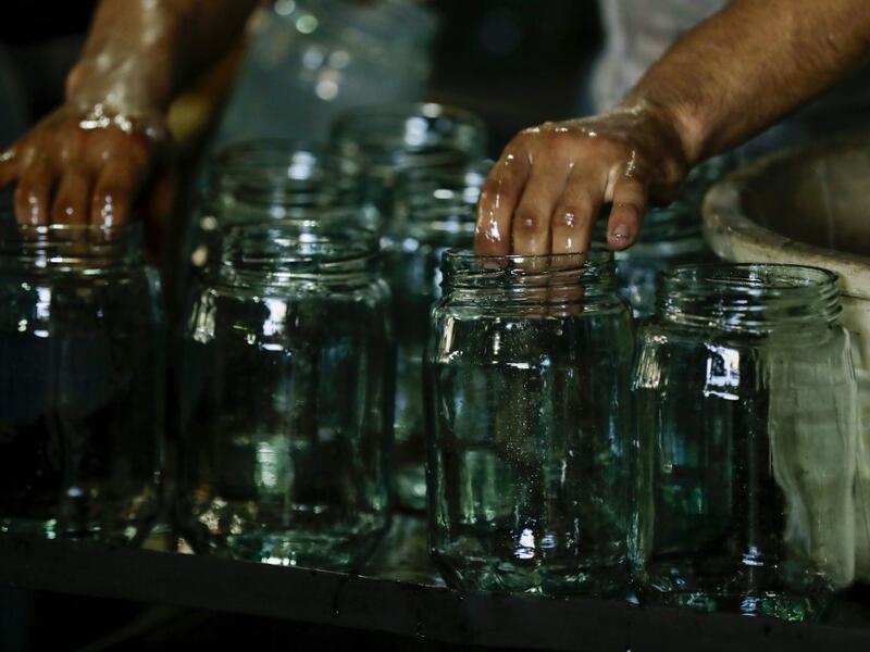 A worker washes jugs at a factory, which is recycling the broken glass as a result of the Beirut explosion, in the northern Lebanese port city of Tripoli on August 25, 2020. The August 4 port explosion ripped through countless glass doors and windows when it laid waste to whole Beirut neighbourhoods, killing at least 190 people and wounding thousands more. Volunteers, non-governmental groups and entrepreneurs salvaged a fraction of the tonnes of broken glass that littered the streets, some of it through rec