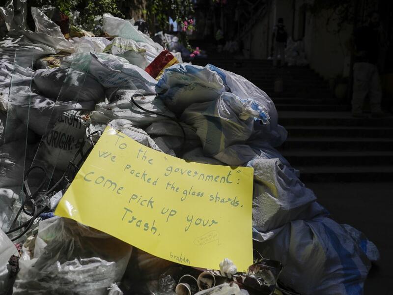 A picture taken on August 24, 2020, shows a note left by activists over a pile of collected glass in Beirut's Gemmayzeh neighbourhood. The August 4 port explosion ripped through countless glass doors and windows when it laid waste to whole Beirut neighbourhoods, killing at least 190 people and wounding thousands more. Volunteers, non-governmental groups and entrepreneurs salvaged a fraction of the tonnes of broken glass that littered the streets, some of it through recycling at Wissam Hammoud's family's gla