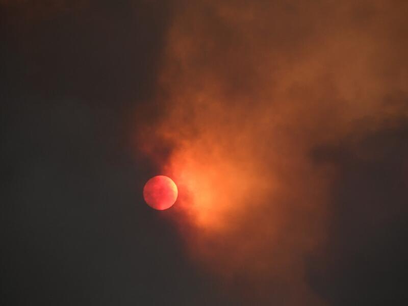 The sun is seen behind smoke from the Bobcat fire rising above in the Angeles National Forest above Duarte, California, about 27 miles (43 km) northeast of Los Angeles, September 7, 2020. Eight national forests in California have been closed as firefighters battle blazes across the state which is in the grips of a record-setting heat wave. Robyn Beck / AFP