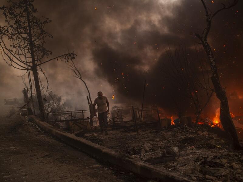 A man carrying belongings flees flames after a major fire broke out in the Moria migrants camp on the Greek Aegean island of Lesbos, on September 9, 2020.
