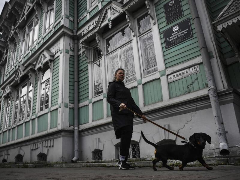 A woman walks a dog past former house of Russian architect Stanislav Khomich, 1904, a traditional wooden house in the Siberian city of Tomsk, on September 8, 2020. Tomsk is considered to be one of the oldest towns in Siberia founded in 1604. Wooden architecture is one of the symbols of the city of Tomsk, its distinctive feature. Today Tomsk is the only city in Siberia where the background wooden buildings have been preserved, reflecting the manor structure of the city streets. Unfortunately, many wooden hou