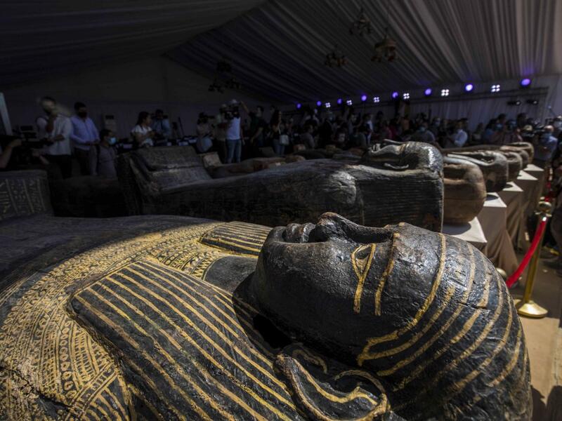 A picture taken on October 3, 2020 shows sarcophaguses, excavated by the Egyptian archaeological mission which discovered a deep burial well with more than 59 human coffins closed for more than 2,500 years, displayed during a press conference at the Saqqara necropolis, 30 kms south of the Egyptian capital Cairo. They were unearthed south of Cairo in the sprawling burial ground of Saqqara, the necropolis of the ancient Egyptian capital of Memphis, a UNESCO World Heritage site. Their exteriors are covered in 
