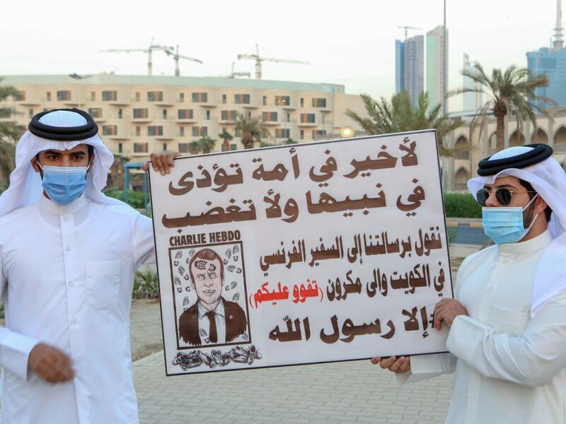 Kuwaitis lift placards expressing anger at French President Emmanuel Macron at a rally in front of the country's National Assembly (parliament) in Kuwait City, on October 24, 2020. Several Middle Eastern countries have slammed comments by President Emmanuel Macron defending cartoons of the Prophet Mohammed, with some instituting boycotts of French goods. AFP