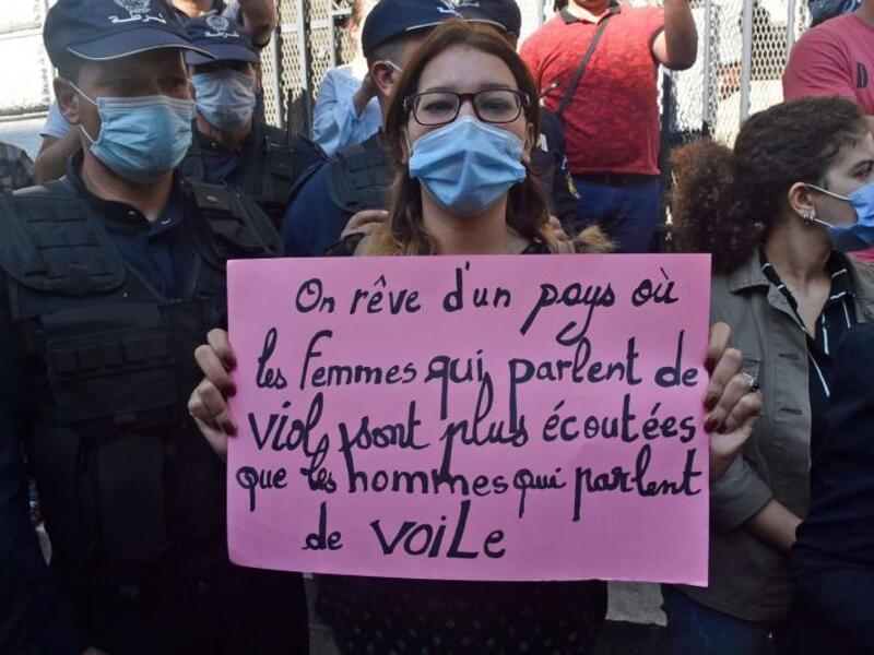 An Algerian activist holds a placard reading in French, “We dream of a country where women who talk about rape are listened to more than men who talk about the veil” during a rally in the capital Algiers, this month. (AFP)
